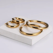 Classic Hoops – Waterproof gouden oorbellen op witte achtergrond – Meena Rotterdam