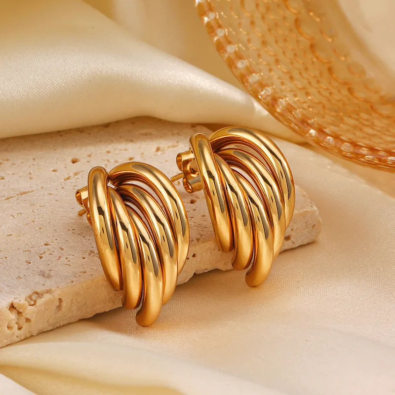 Decadent – Waterproof gouden oorbellen op gestylde achtergrond – Meena Rotterdam